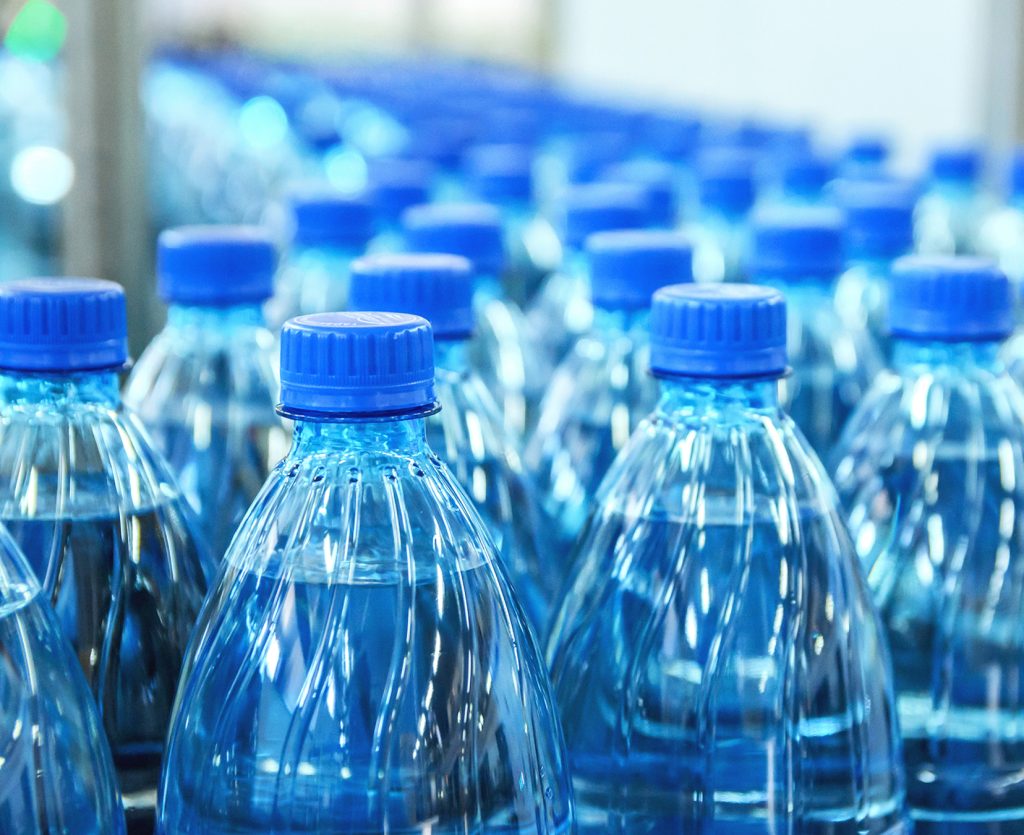 Closeup on mineral water green bottles in raw and lines